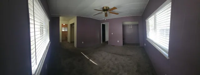 a view of a big room with windows and chandelier