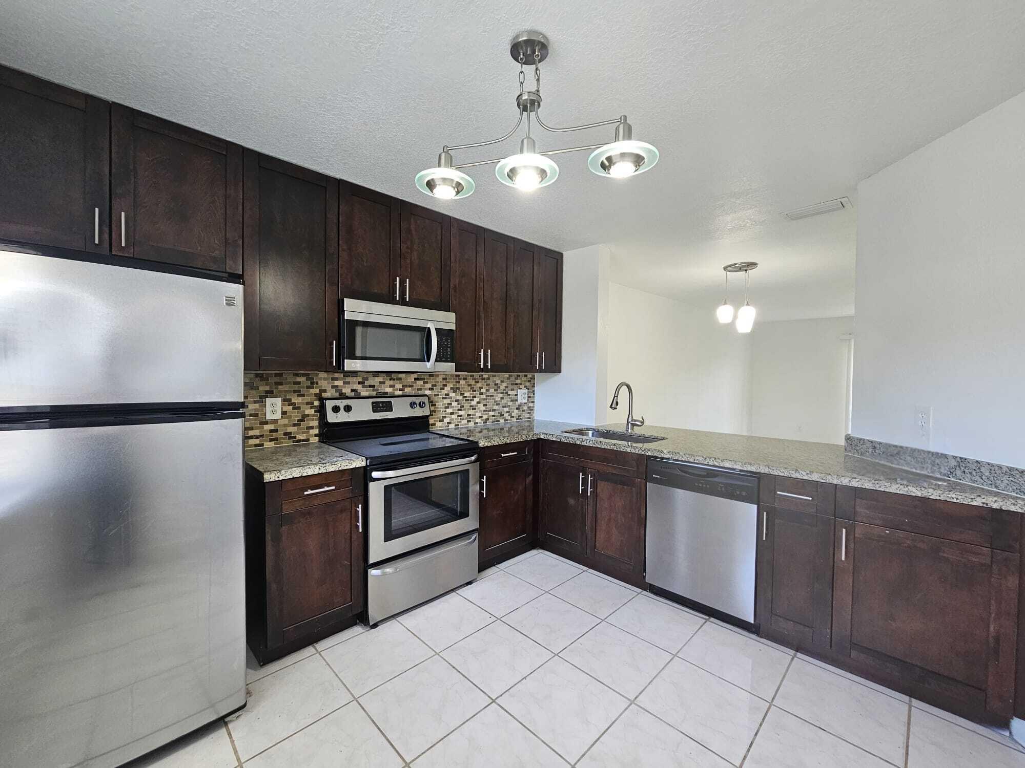 6342 Walk Circle Boca Raton, FL 33433 - Photo 3 of 10 a large kitchen with cabinets and stainless steel appliances