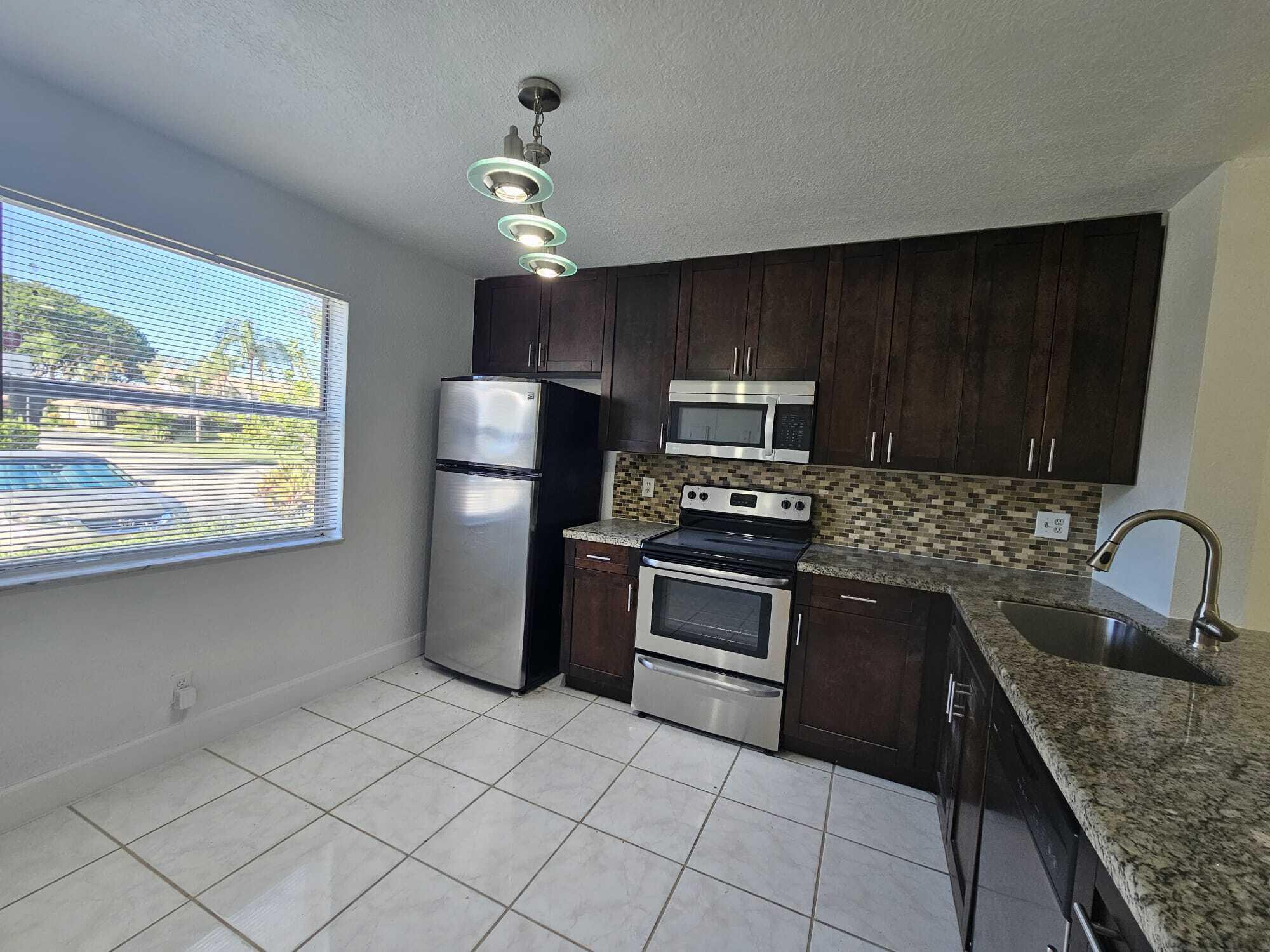 6342 Walk Circle Boca Raton, FL 33433 - Photo 4 of 10 a kitchen with a stove a sink and a microwave