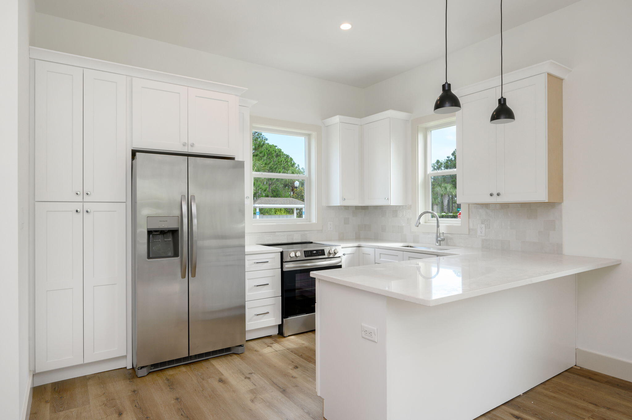 114 Enchanted Way Santa Rosa Beach, FL 32459 - Photo 2 of 38 a kitchen with stainless steel appliances granite countertop a refrigerator a sink a stove and white cabinets with wooden floor