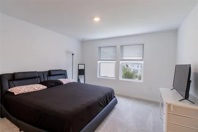 a bedroom with a bed tv and window