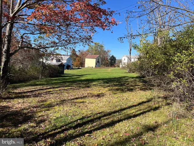 a view of a yard with wooden fence