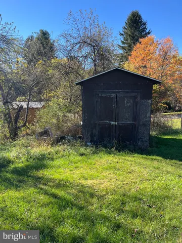 a house is sitting in middle of the green field