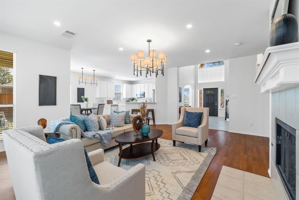 a living room with furniture a fireplace and a chandelier