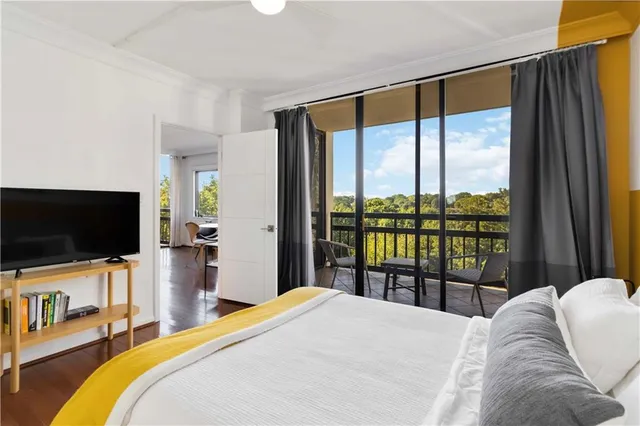 a bedroom with a large window and a flat screen tv