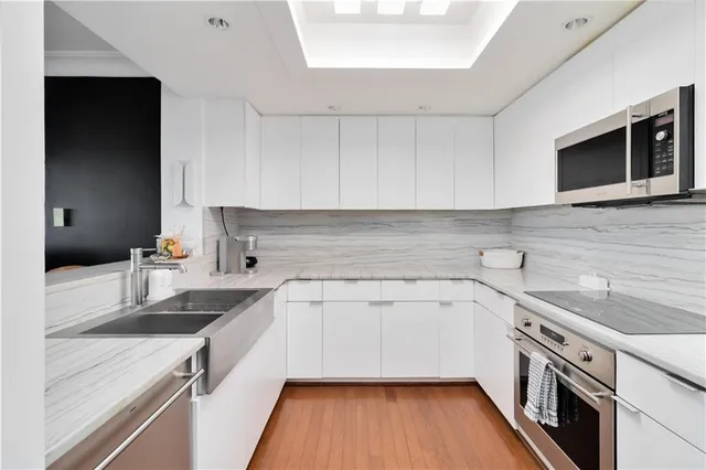 a kitchen with a sink dishwasher stove and microwave with wooden floor