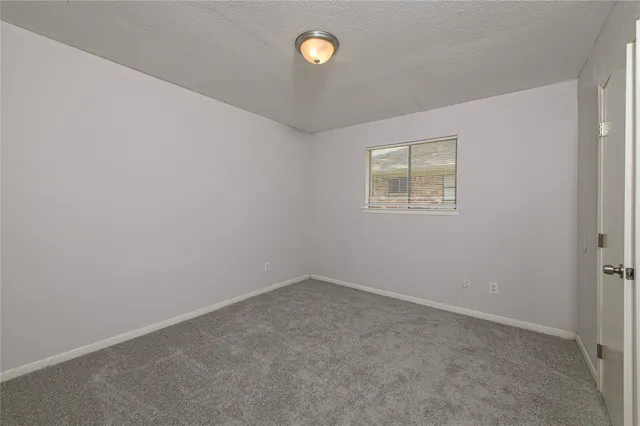 an empty room with a fan and a window