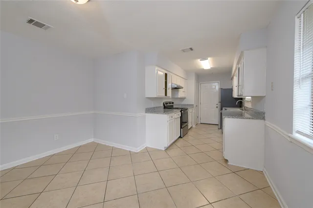 a kitchen with white cabinets and appliances