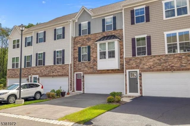 a front view of a house with a garden and parking space