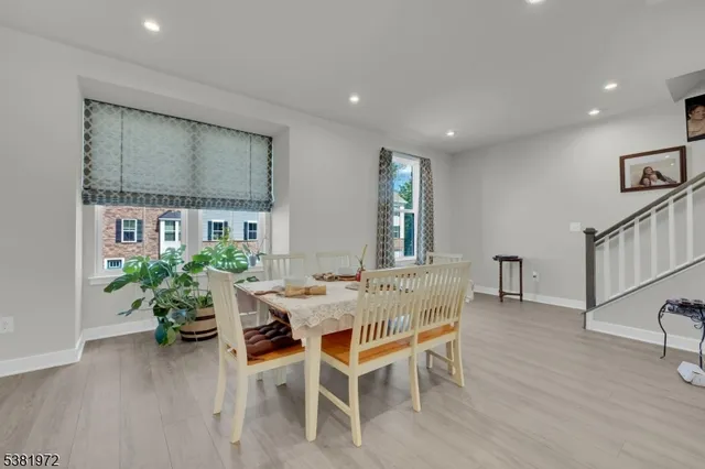 a dining room with furniture potted plants and wooden floor