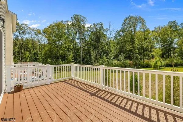 a balcony with wooden floor and trees in the background