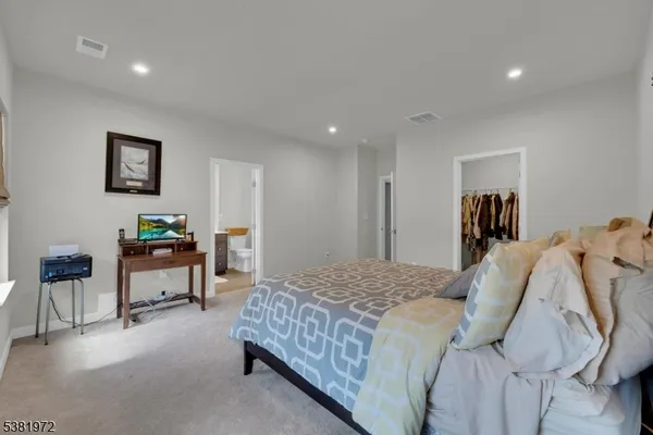 a spacious bedroom with a bed and a book shelf