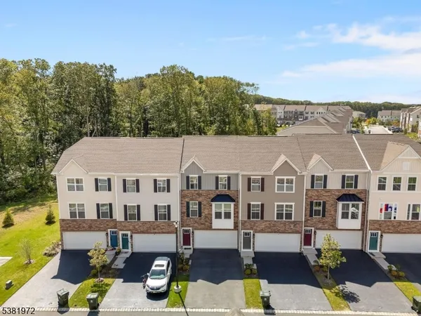 a front view of residential houses with yard and trees