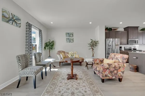 a living room with furniture and a view of kitchen