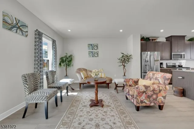 a living room with furniture and a view of kitchen