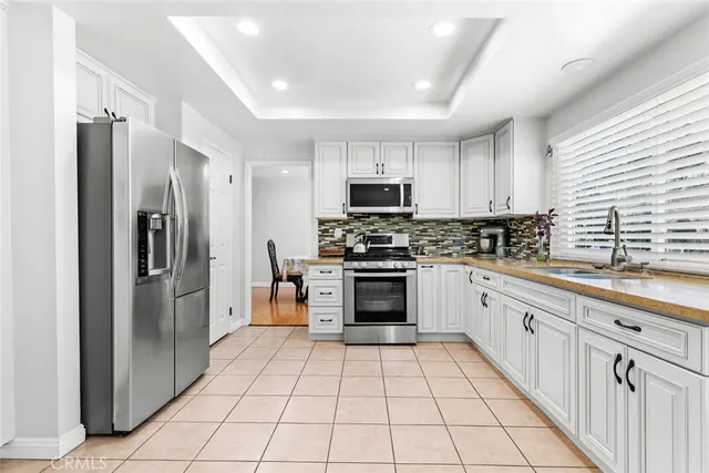 a kitchen with stainless steel appliances granite countertop a refrigerator and a stove top oven