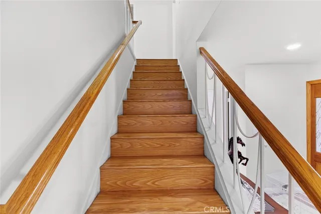 a view of a hallway with wooden floor and staircase
