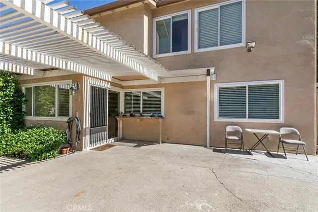a view of a house with backyard and sitting area