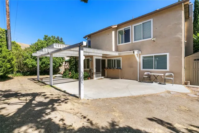 a front view of a house with a yard and tree s