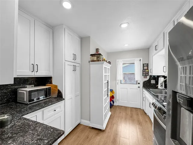 a kitchen with stainless steel appliances granite countertop a stove a sink and a refrigerator