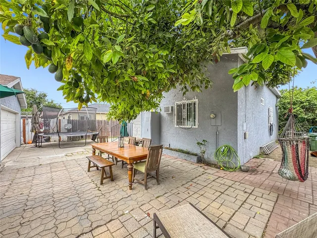 a patio with table and chairs and potted plants