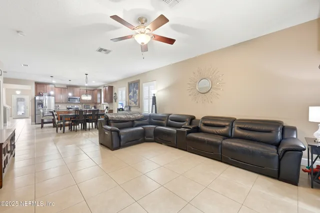 a living room with furniture and a view of kitchen
