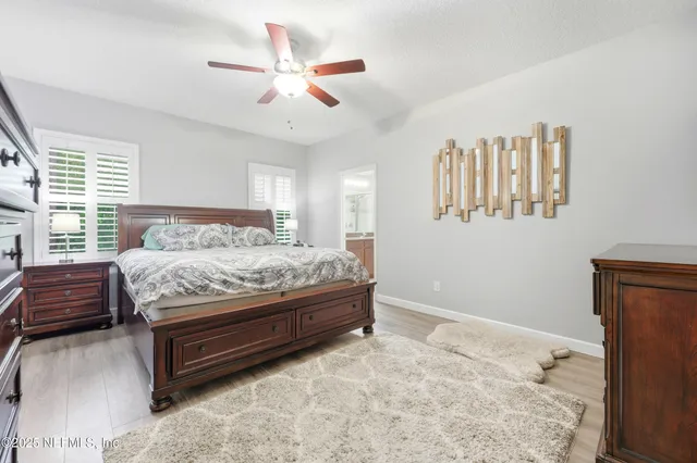 a bedroom with a bed next to a window and a chandelier