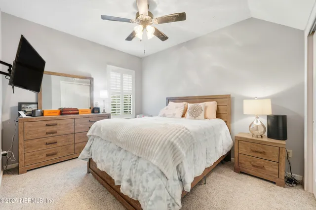 a bedroom with a large bed and a flat tv screen on dresser