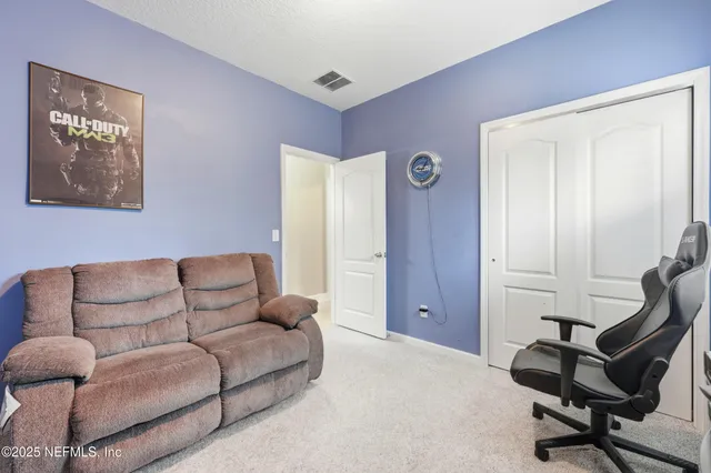 a living room with furniture and a air conditioner vent