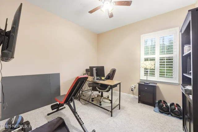 a view of a workspace with furniture and a window