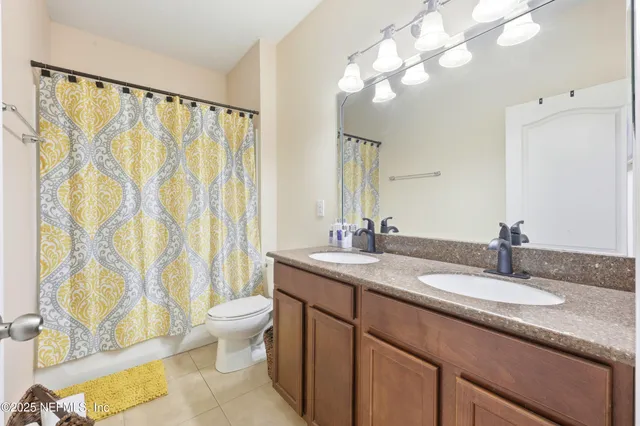 a bathroom with a granite countertop sink a toilet and a mirror