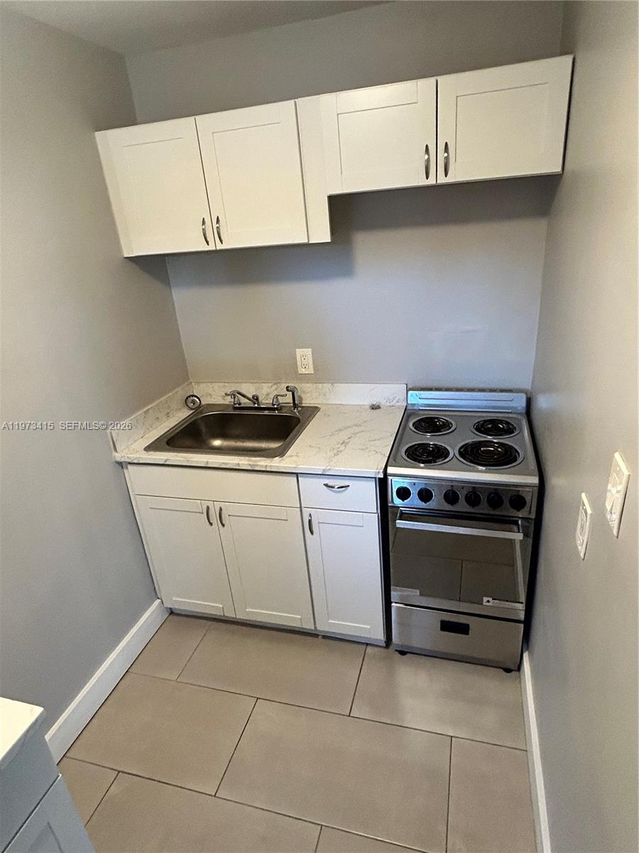 1150 Northwest 1st Place, Unit 2 Miami, FL 33136 - Photo 12 of 19 a kitchen with cabinets appliances and a sink