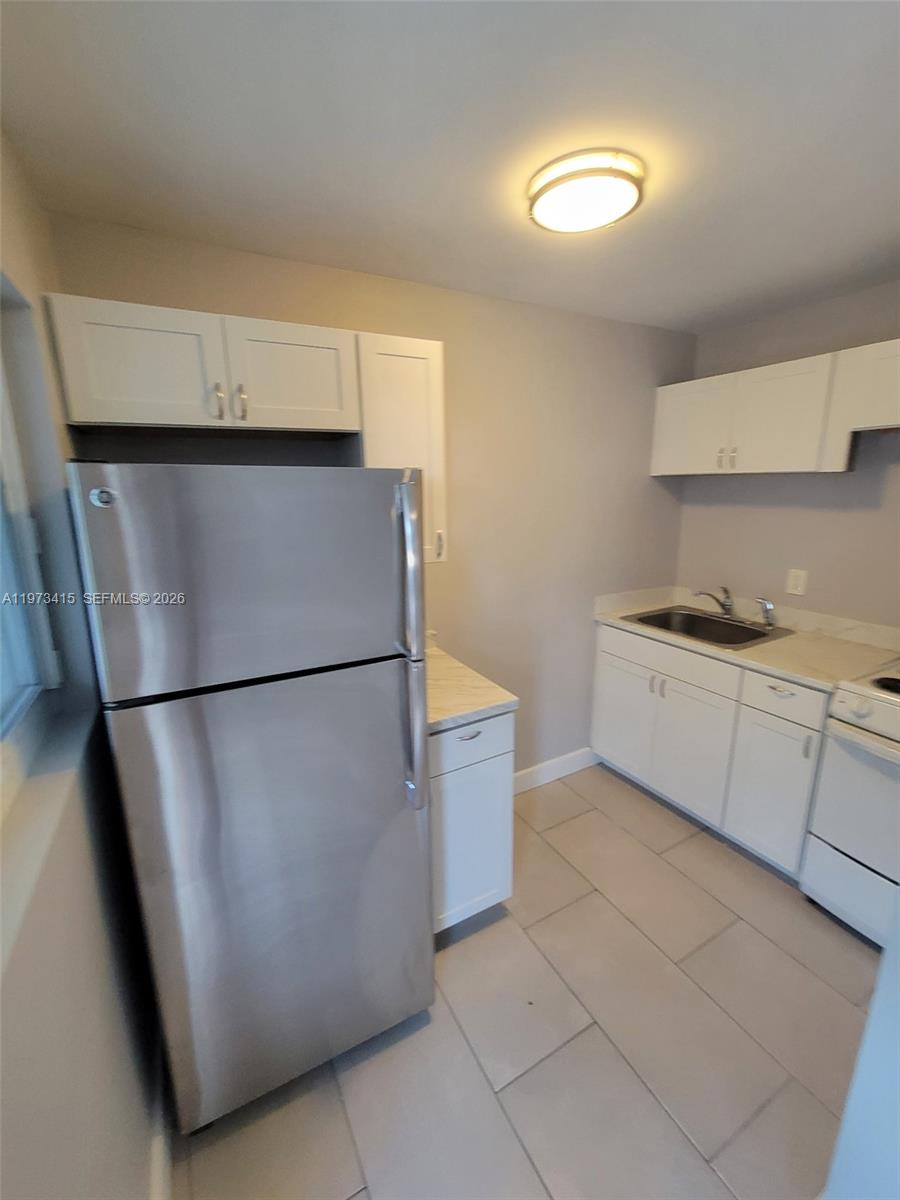 1150 Northwest 1st Place, Unit 2 Miami, FL 33136 - Photo 13 of 19 a white refrigerator freezer sitting in a kitchen