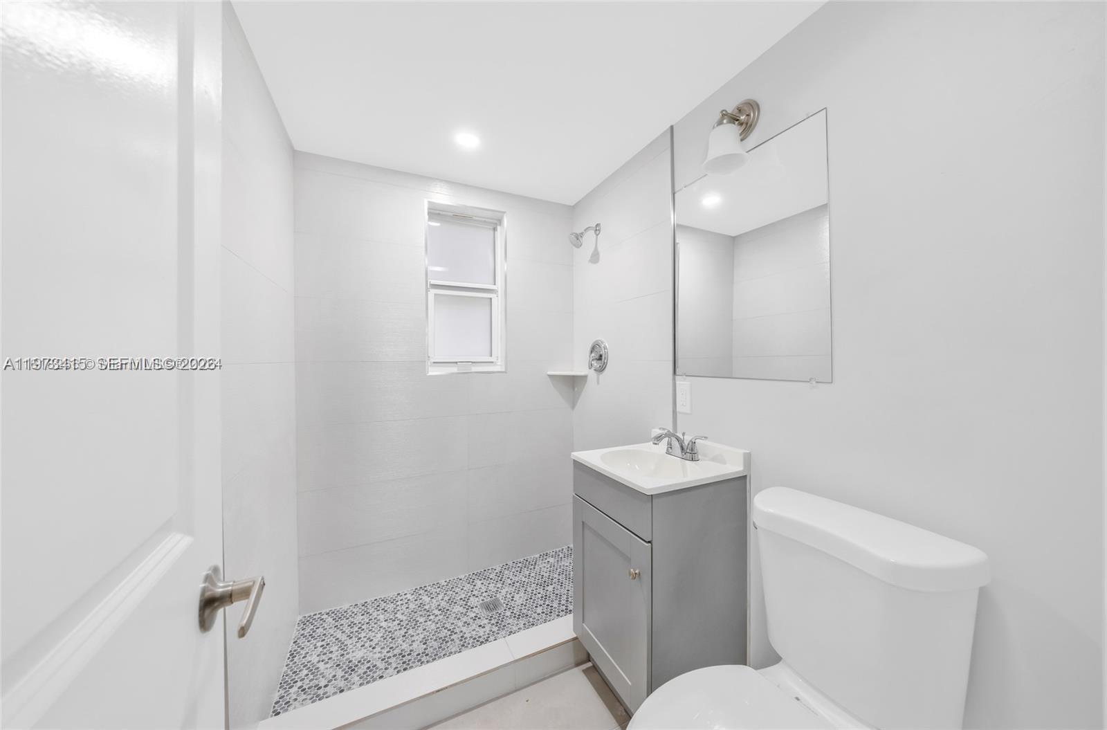 1150 Northwest 1st Place, Unit 2 Miami, FL 33136 - Photo 7 of 19 a bathroom with a sink toilet and shower