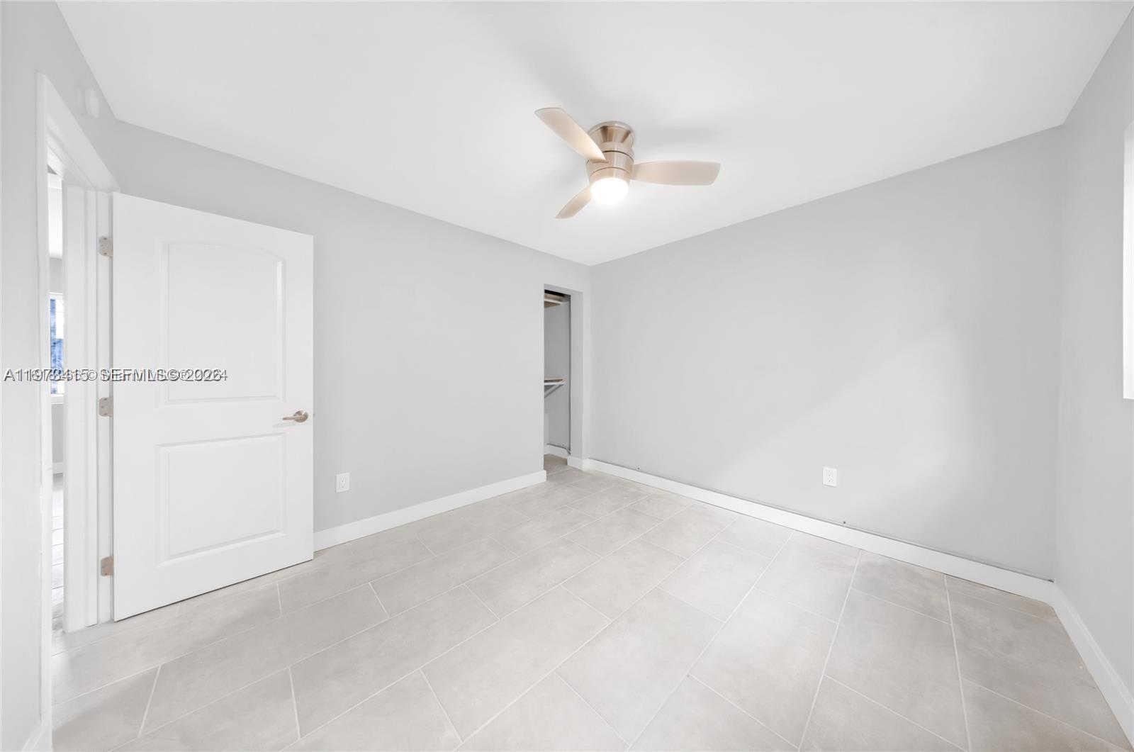 1150 Northwest 1st Place, Unit 2 Miami, FL 33136 - Photo 9 of 19 an empty room with a ceiling fan and carpet