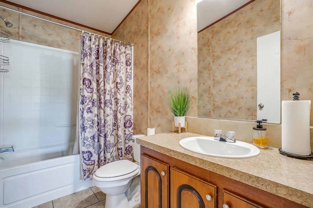 321 Young Road Millsap, TX 76066 - Photo 23 of 28 a bathroom with a granite countertop sink toilet and shower