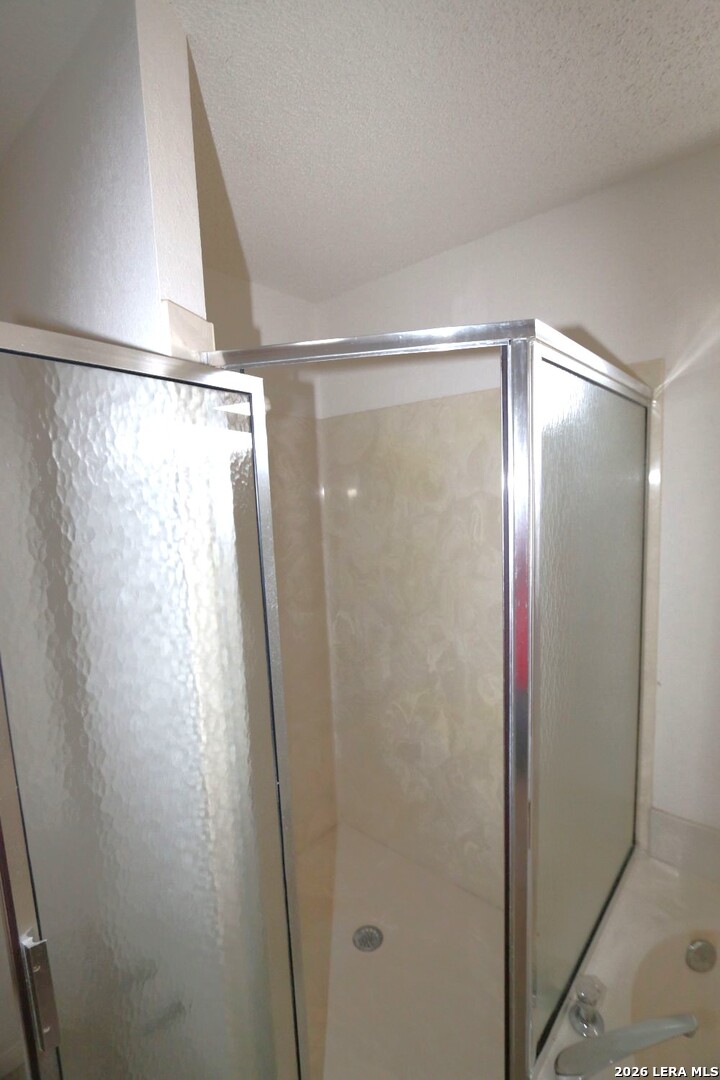 802 Athens Street Castroville, TX 78009 - Photo 23 of 44 a bathroom with a glass shower door