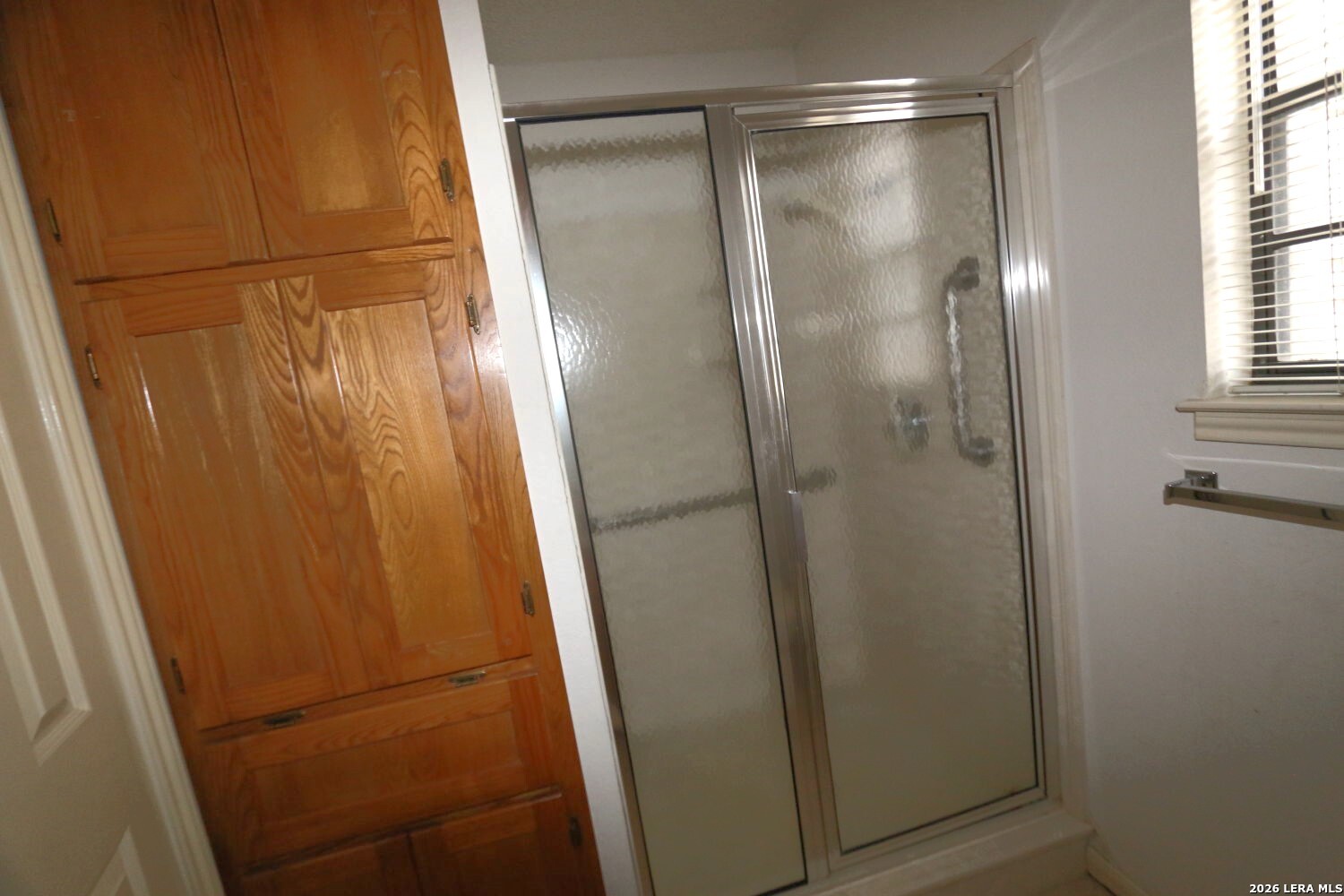 802 Athens Street Castroville, TX 78009 - Photo 28 of 44 a bathroom with a glass shower door