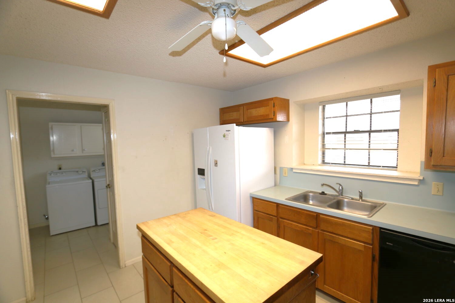 802 Athens Street Castroville, TX 78009 - Photo 30 of 44 a kitchen with a sink a refrigerator and cabinets