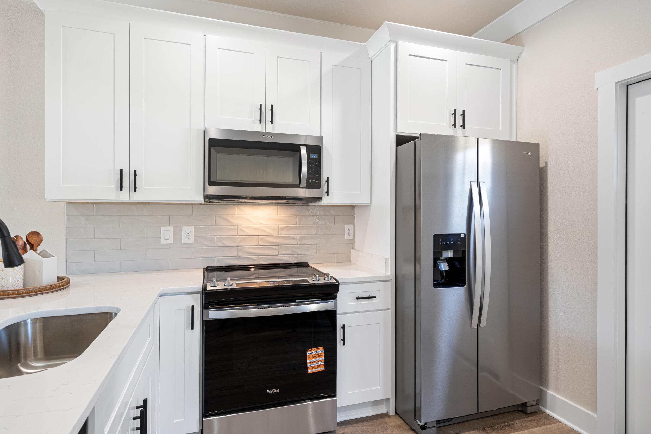 873 Brett Street South Crestview, FL 32539 - Photo 18 of 50 a kitchen with stainless steel appliances white cabinets white stove a microwave and a refrigerator