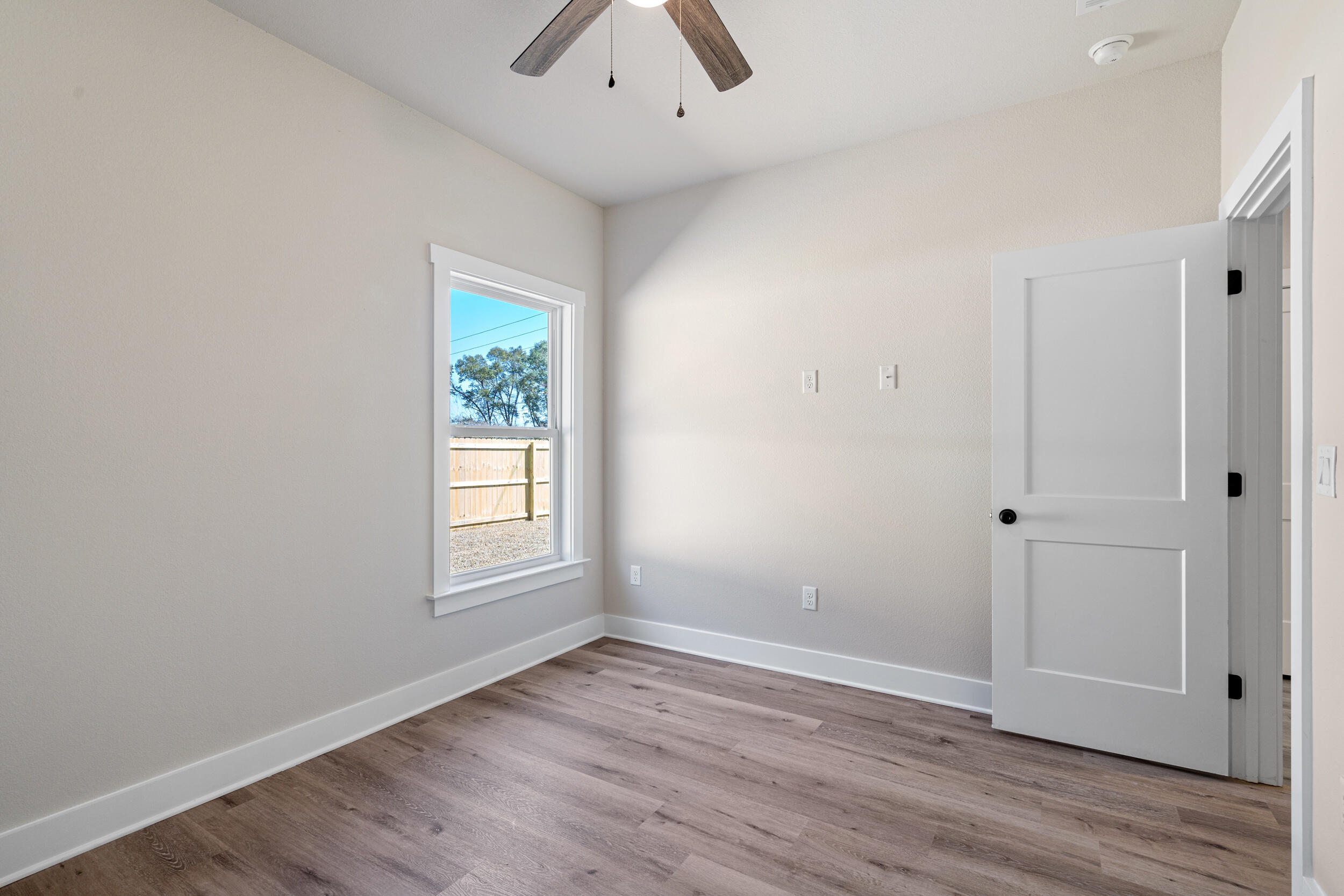 873 Brett Street South Crestview, FL 32539 - Photo 25 of 50 an empty room with wooden floor and window