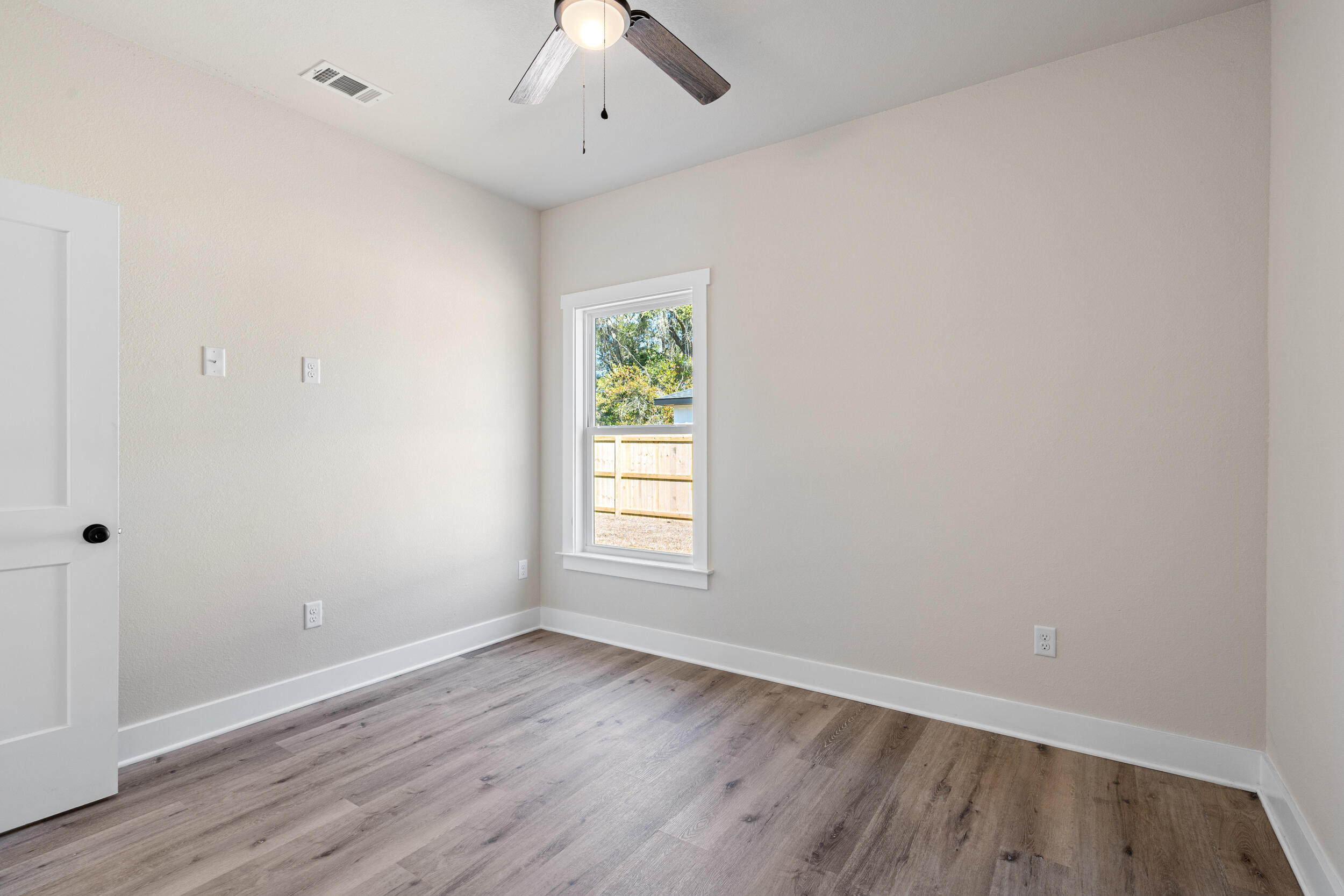 873 Brett Street South Crestview, FL 32539 - Photo 27 of 50 an empty room with wooden floor and window