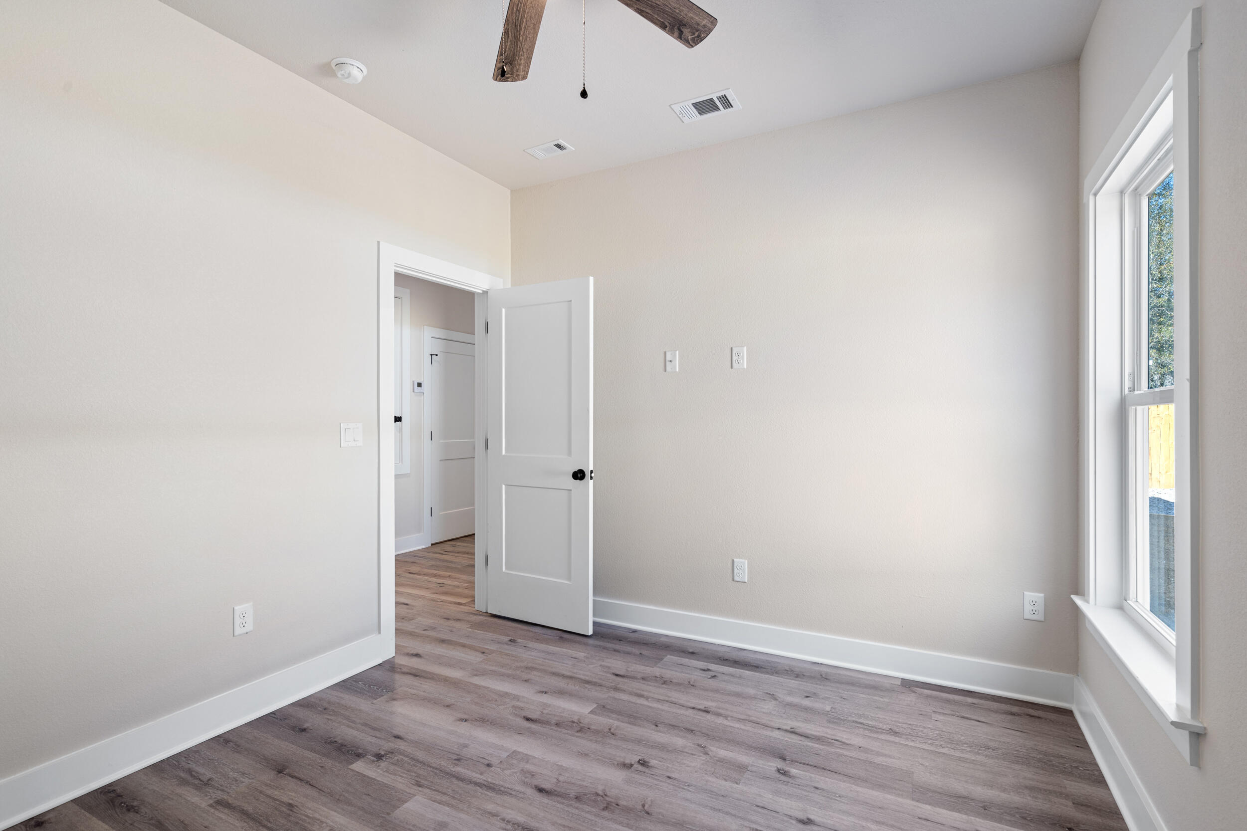 873 Brett Street South Crestview, FL 32539 - Photo 28 of 50 an empty room with wooden floor and window