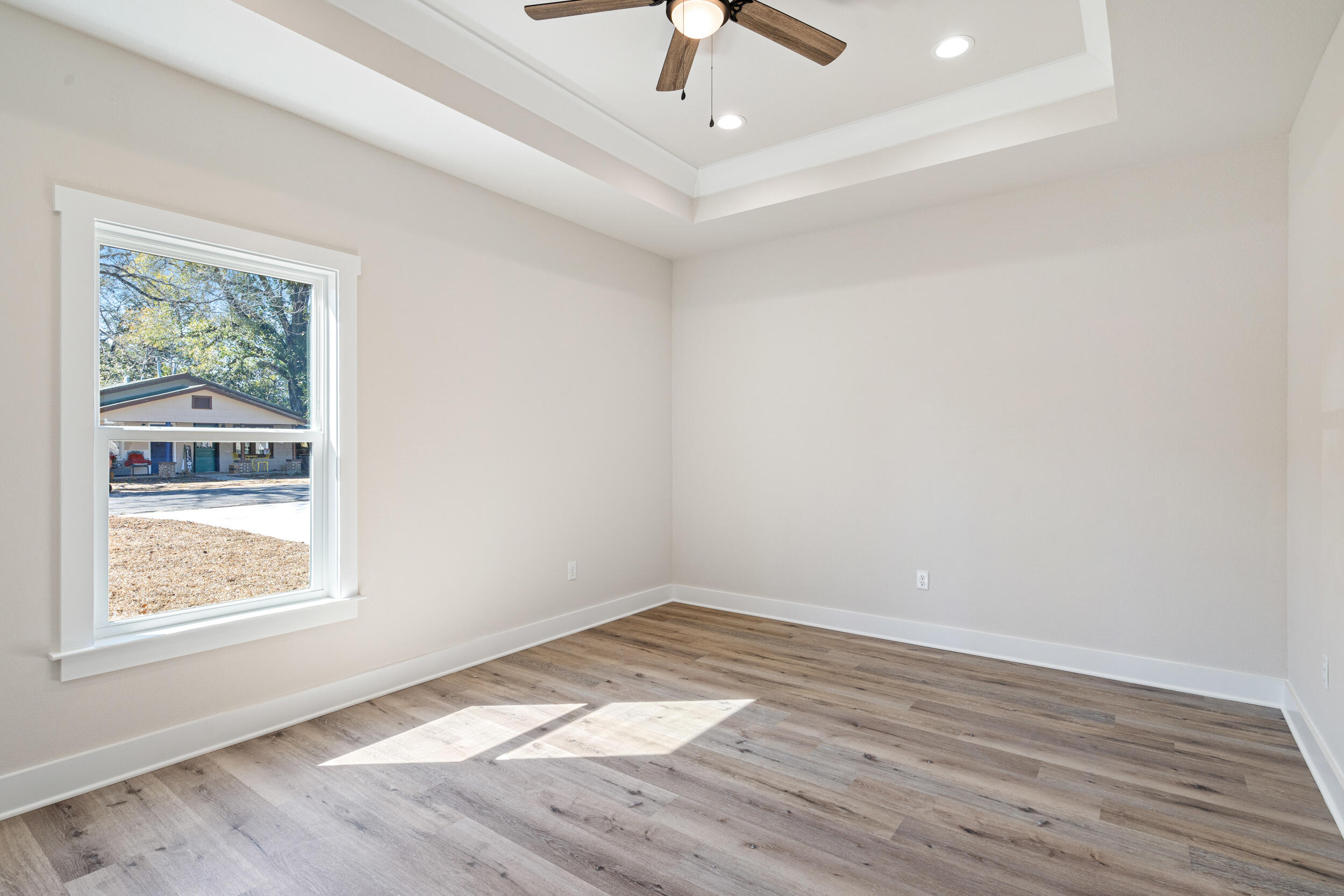 873 Brett Street South Crestview, FL 32539 - Photo 31 of 50 an empty room with wooden floor chandelier fan and windows