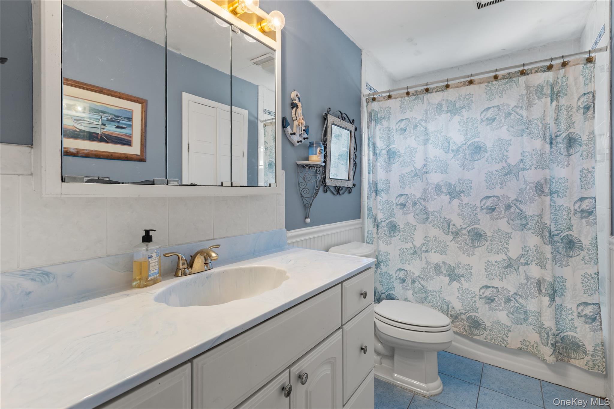 116 Cross Road Oakdale, NY 11769 - Photo 11 of 26 a bathroom with a sink a toilet and shower curtain