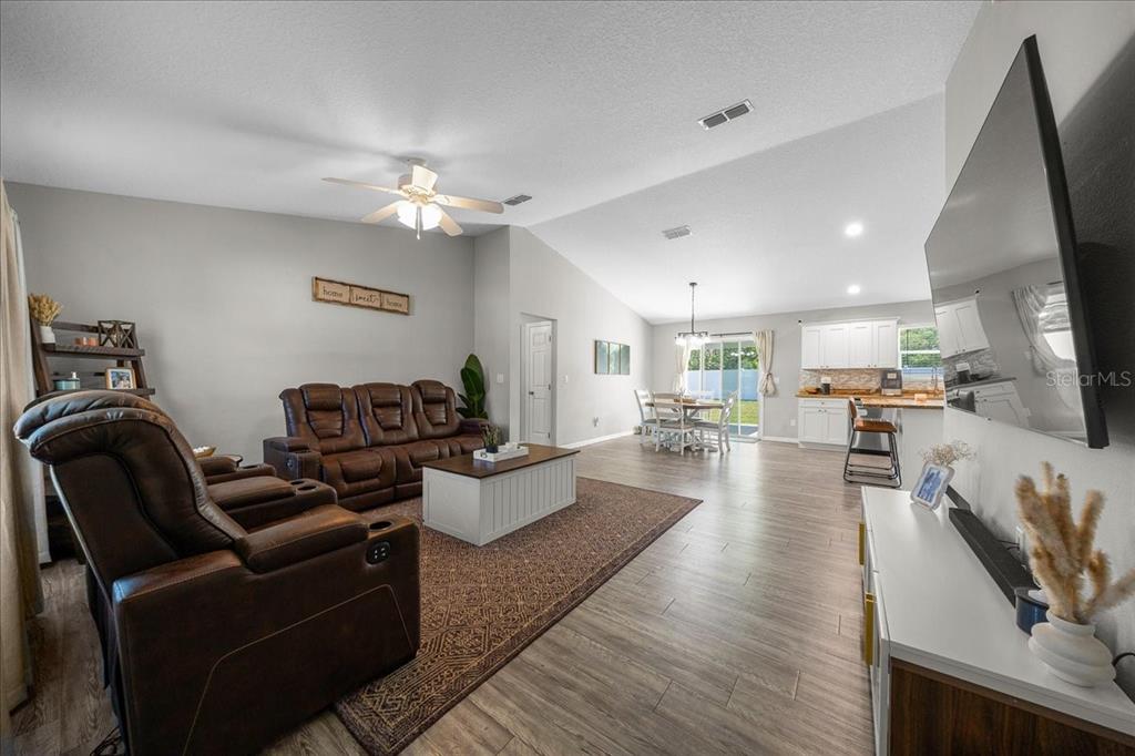 13 Teak Loop Place Ocala, FL 34472 - Photo 15 of 36 a living room with furniture a flat screen tv and kitchen view