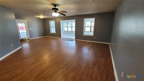 a view of empty room with wooden floor