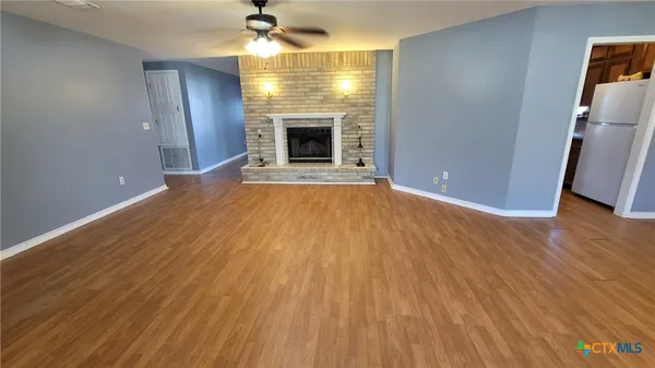 a spacious bedroom with a bed and wooden floor
