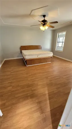 a view of walk in closet with wooden floor and stairs