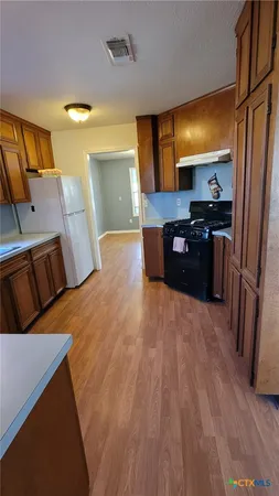 a large kitchen with a wooden floor and a large window